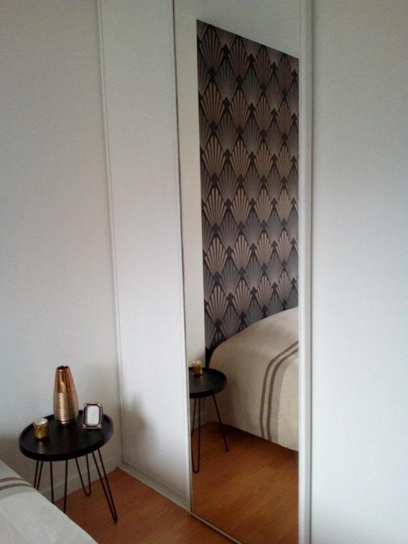 Reflet du panneau Art déco dans la porte miroir du dressing