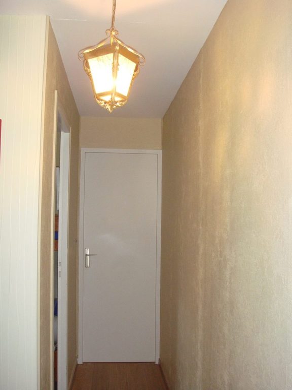 Couloir après peinture, porte blanche et mur chaud aux reflets satinés