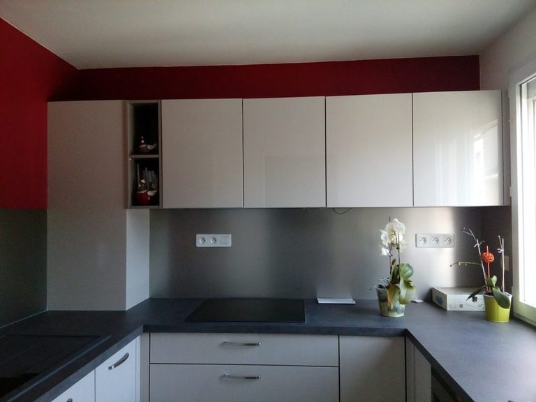 Cuisine en U après peinture — meubles blancs, mur rouge et plan de travail gris anthracite