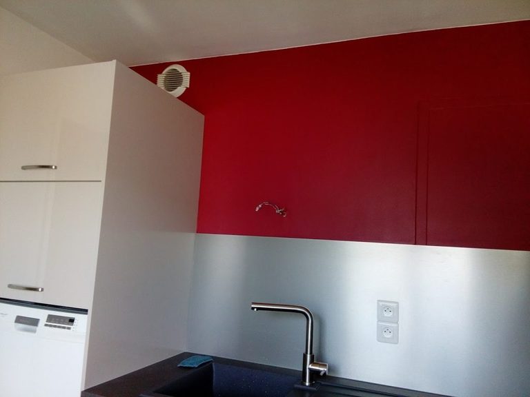Mur rouge sous rampant, colonne de rangement blanche et mitigeur inox