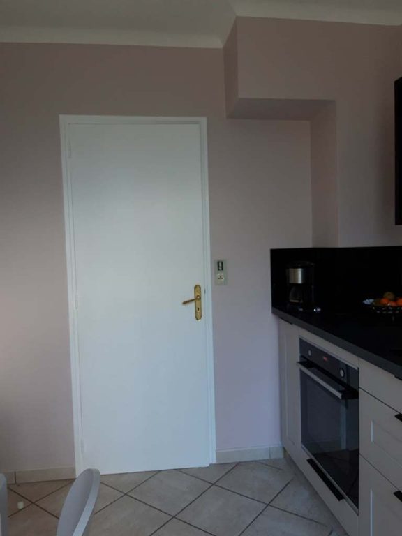 Porte et mur rose poudré en limite de la cuisine