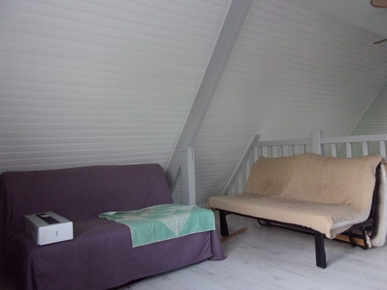 Mezzanine après peinture — lambris blanc, banquette et coin nuit