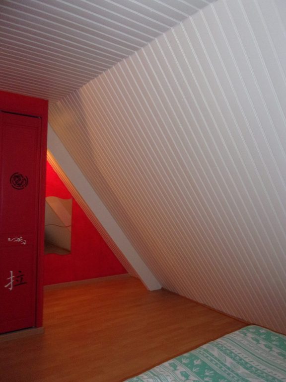 Lambris blanc contrastant avec une porte et un mur rouges