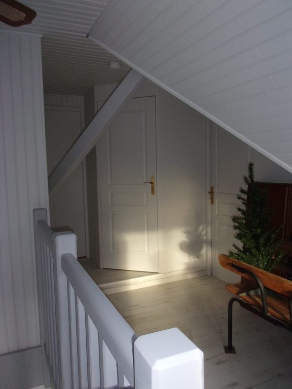 Palier des combles après peinture, porte blanche et lambris clair