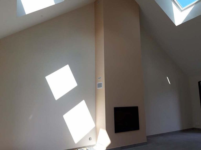 Mur habillé en beige rosé autour du poêle encastré