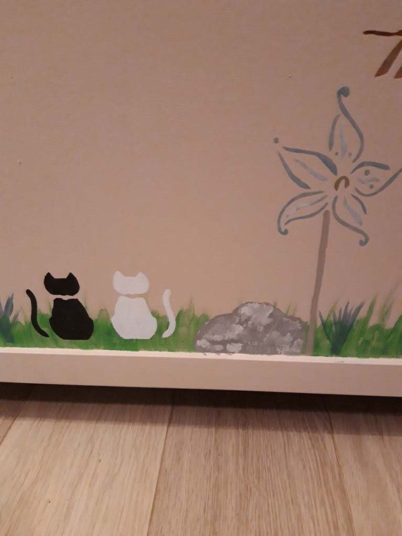 Angle du coffre à jouets : chats, rocher et fleur au pochoir