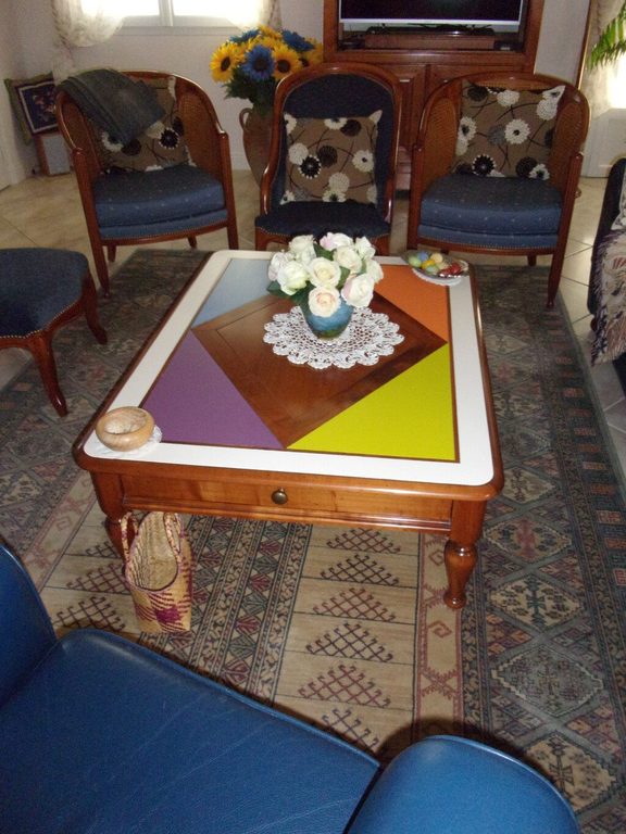 Table basse multicolore posée sur le tapis du salon